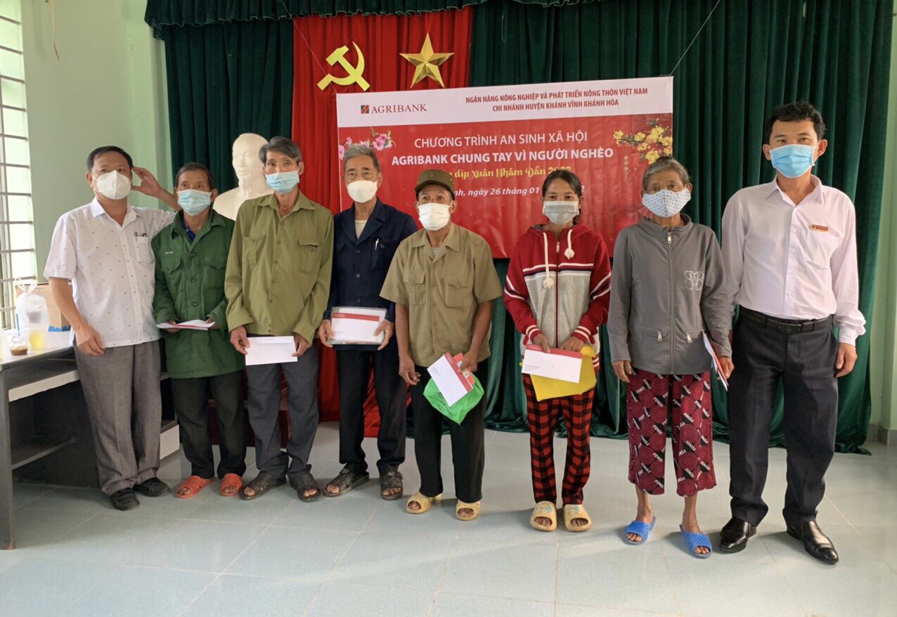 Lãnh đạo Agribank Chi nhánh huyện Khánh Vĩnh và lãnh đạo Phòng Lao động - Thương binh và Xã hội huyện tặng quà Tết cho các hộ dân.