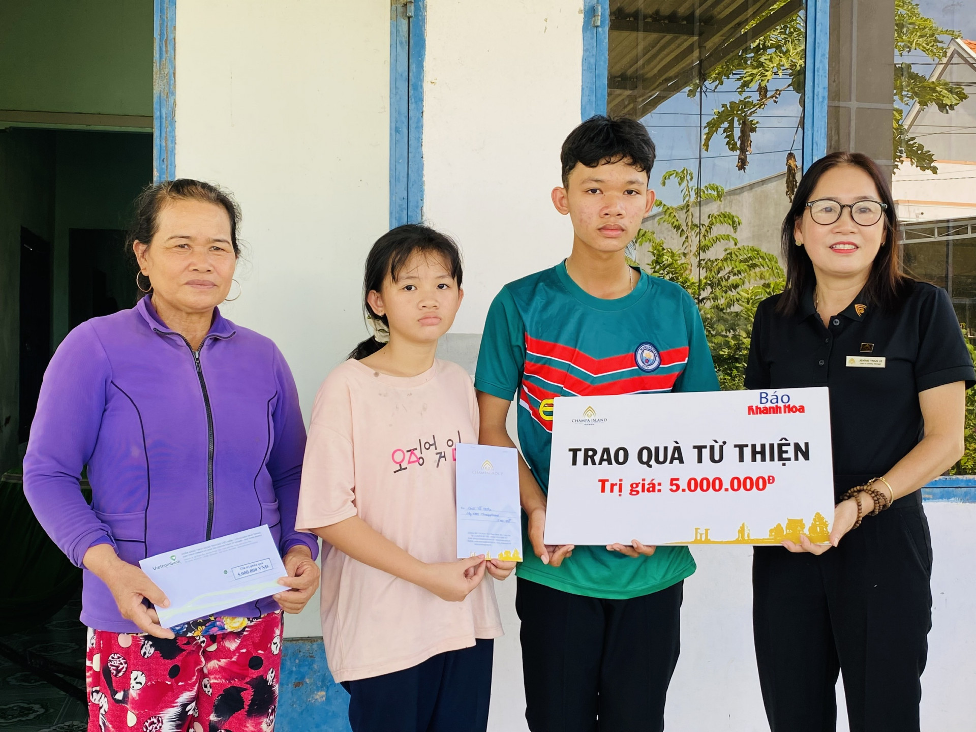 Đại diện Công ty Cổ phần Đầu tư Champagroup - Khu du lịch Champa Island Nha Trang trao tiền ủng hộ cho 2 anh em Trần Thế Văn và Trần Ái Vy