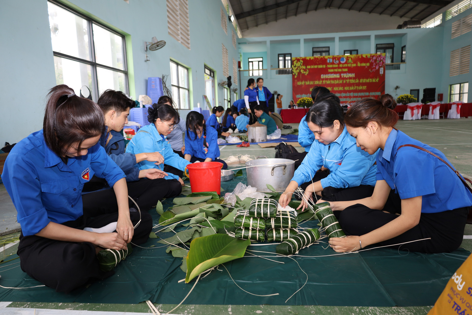 Các đội thi gói bánh chưng, bánh tét.