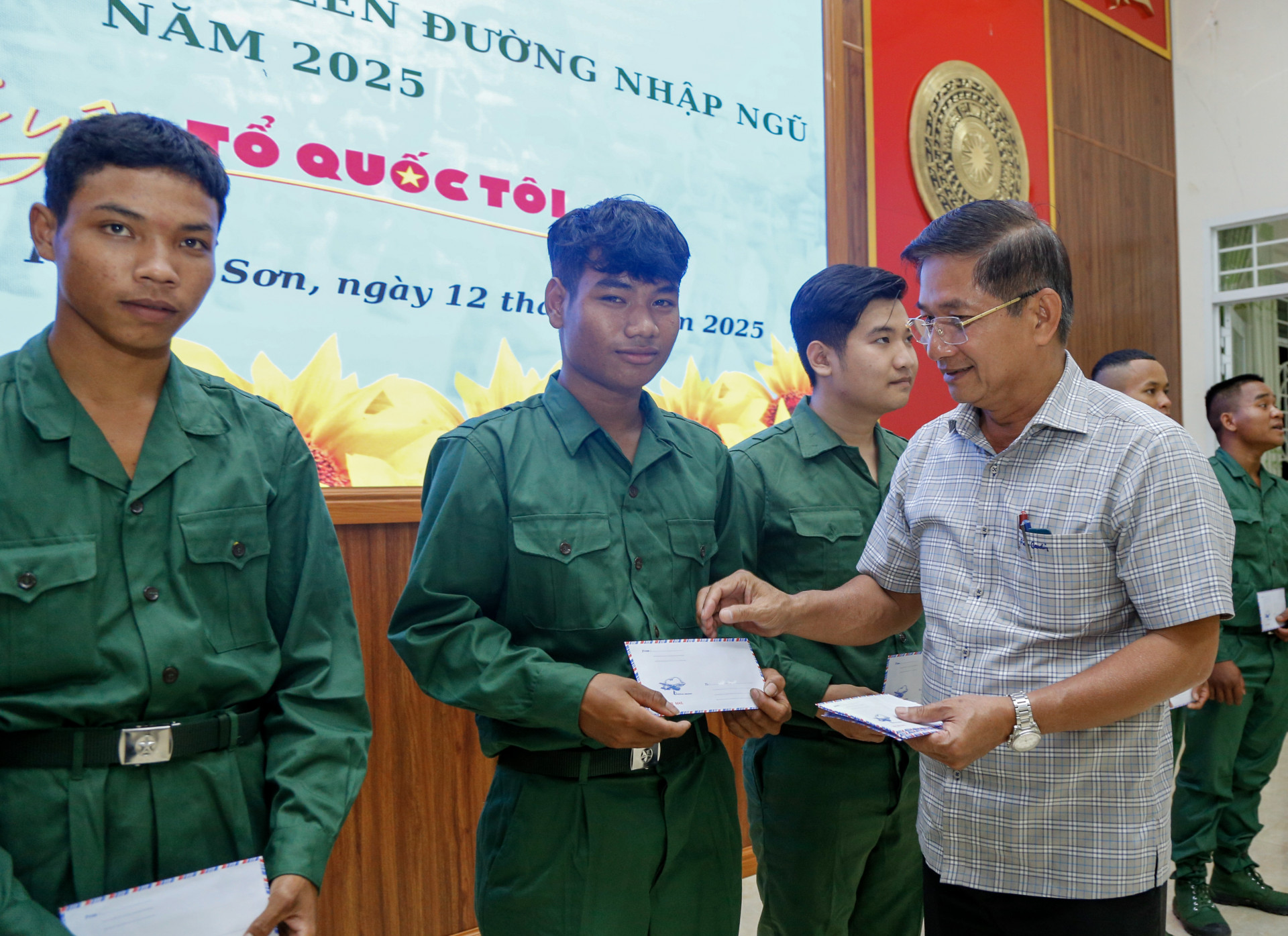 Ông Đinh Văn Dũng - Chủ tịch UBND huyện Khánh Sơn trao quà cho thanh niên được gọi nhập ngũ năm 2025