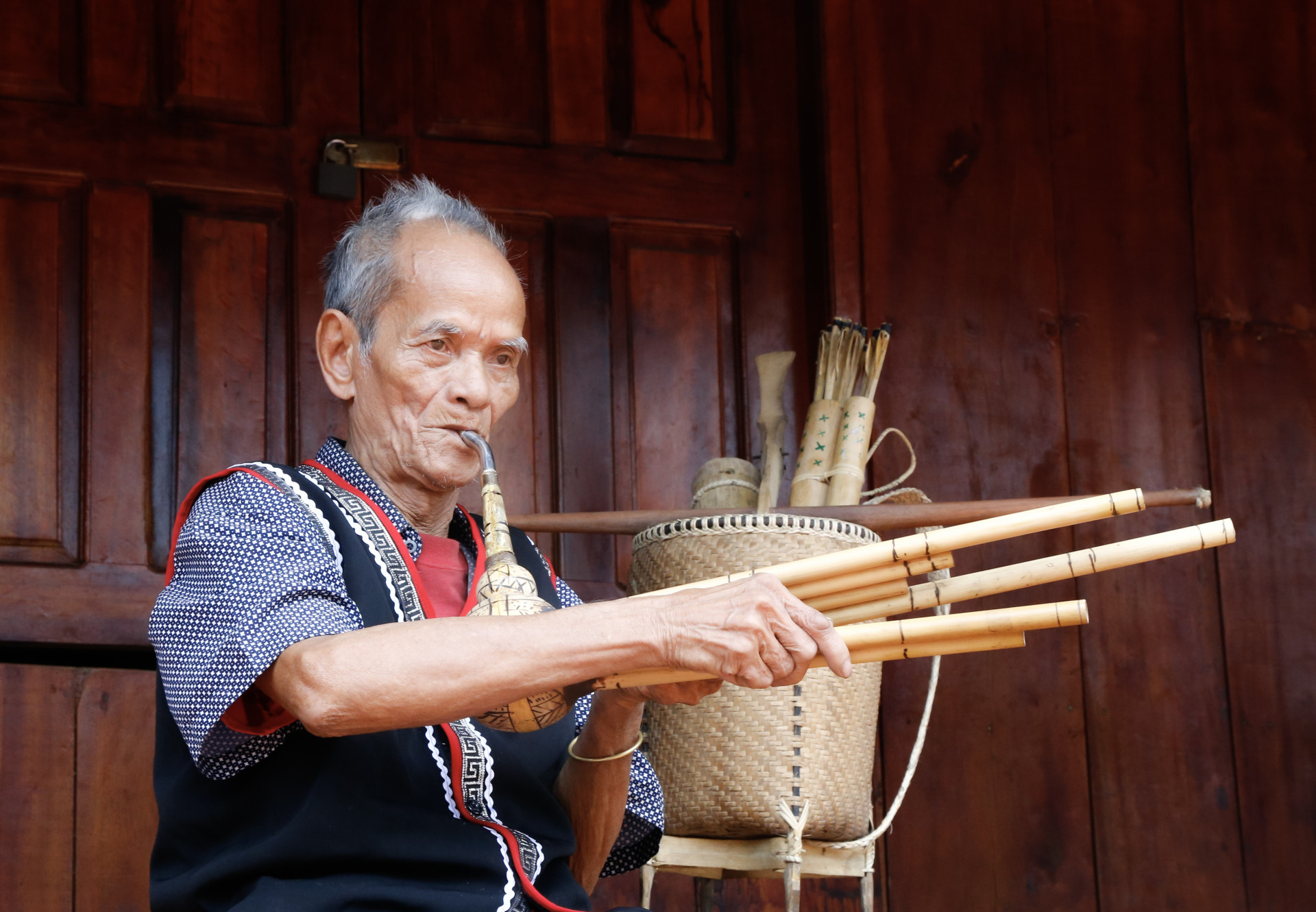 Già Mấu Hồng Thái say sưa biểu diễn khèn bầu dưới nếp nhà dài.