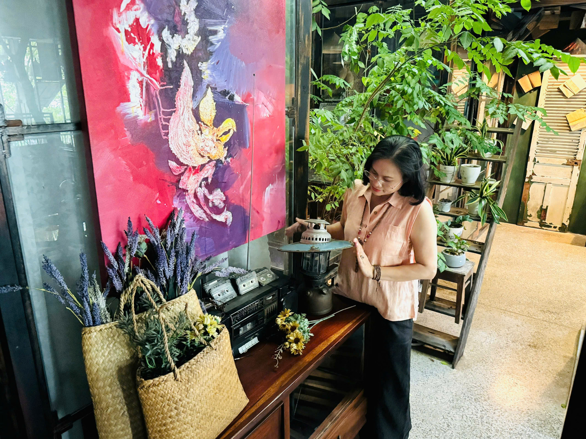 Chị Huệ thích thú với những vật dụng   được trưng bày tại quán.