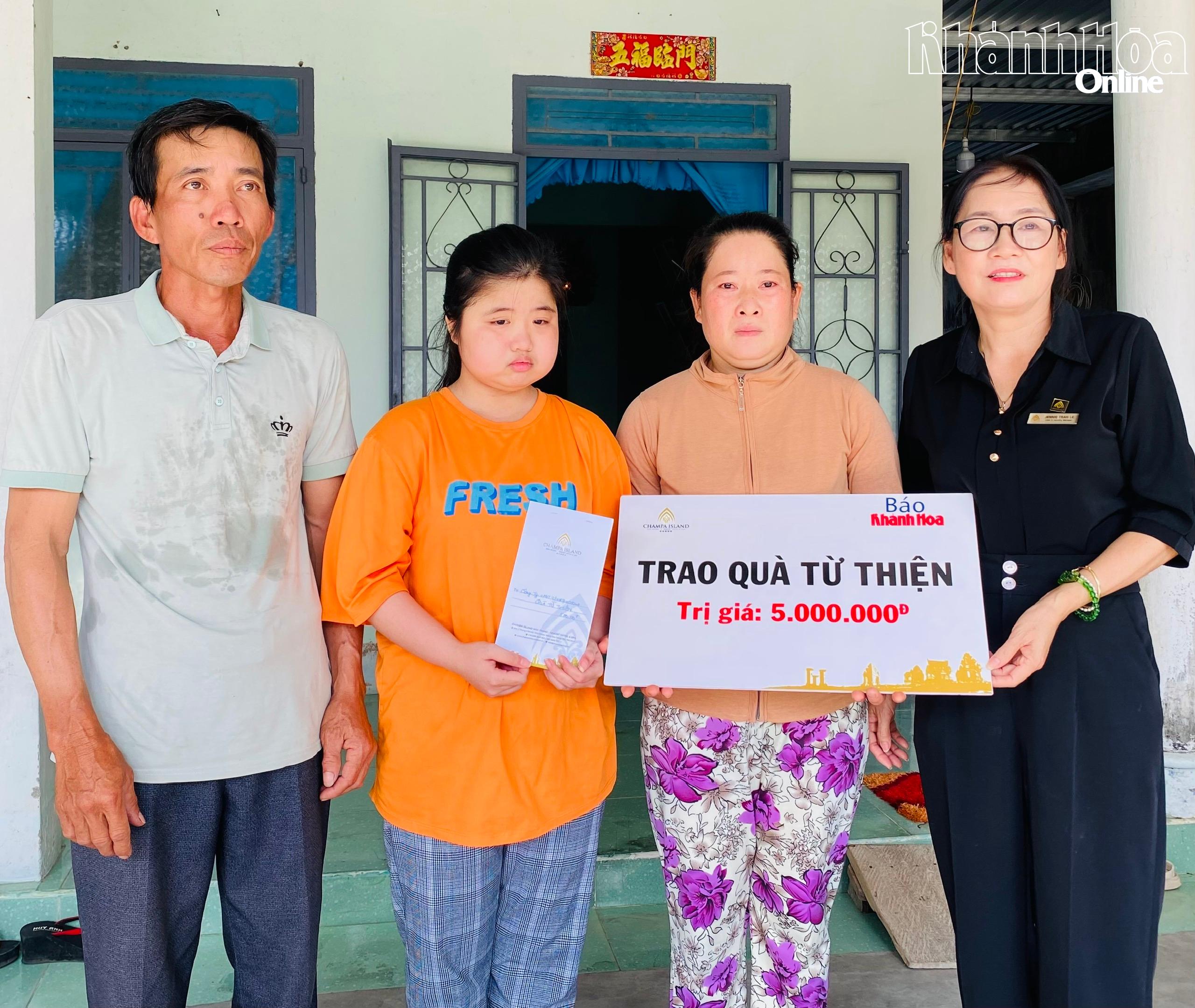 Đại diện Công ty Cổ phần Đầu tư Champagroup - Khu du lịch Champa Island Nha Trang trao tiền ủng hộ cho gia đình em Võ Thị Thu Hân